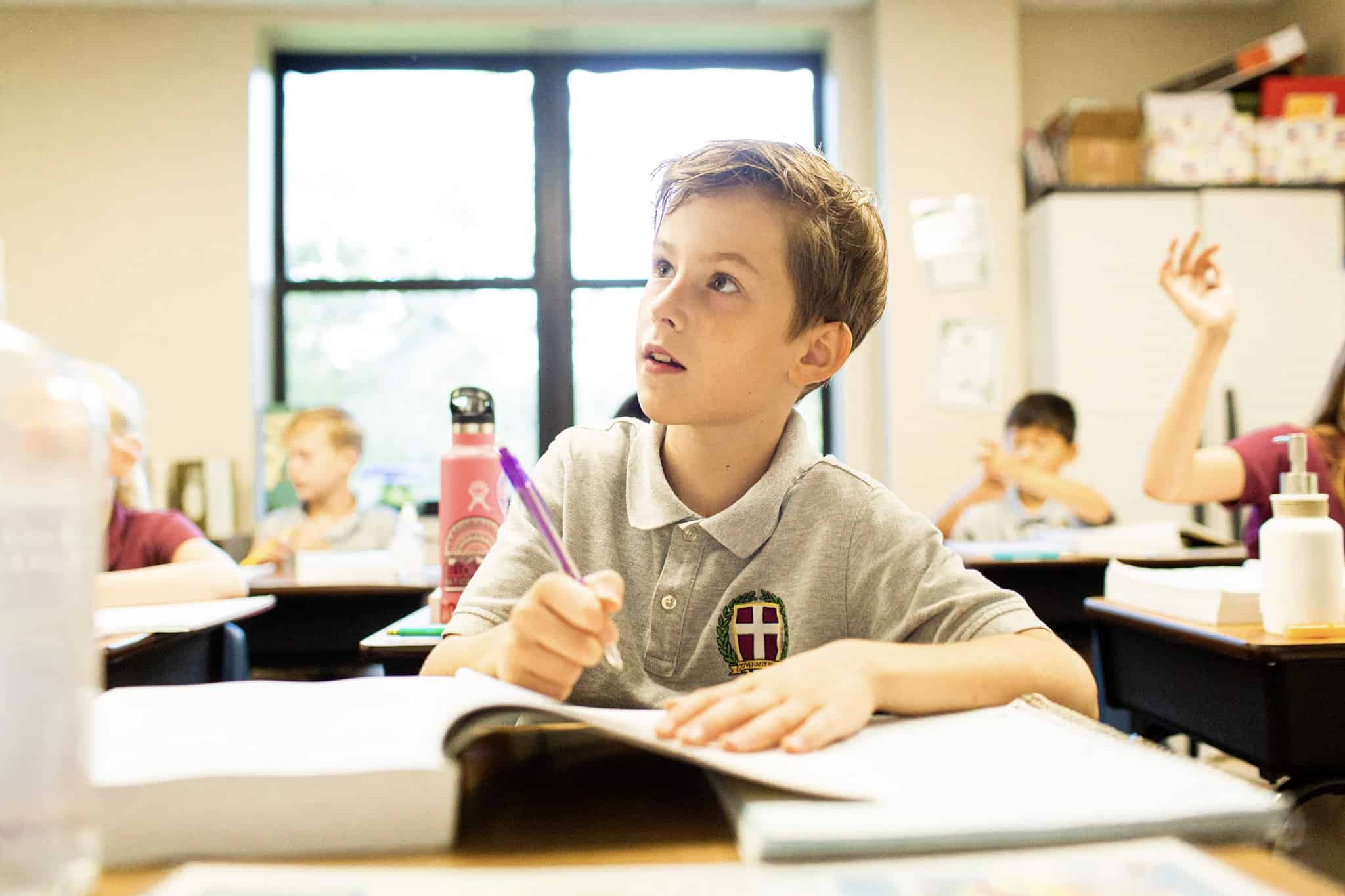 Student participating in hybrid education at Covenant Preparatory School listens to teacher instructions while completing an assignment.